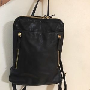 Black leather backpack with gold zippers